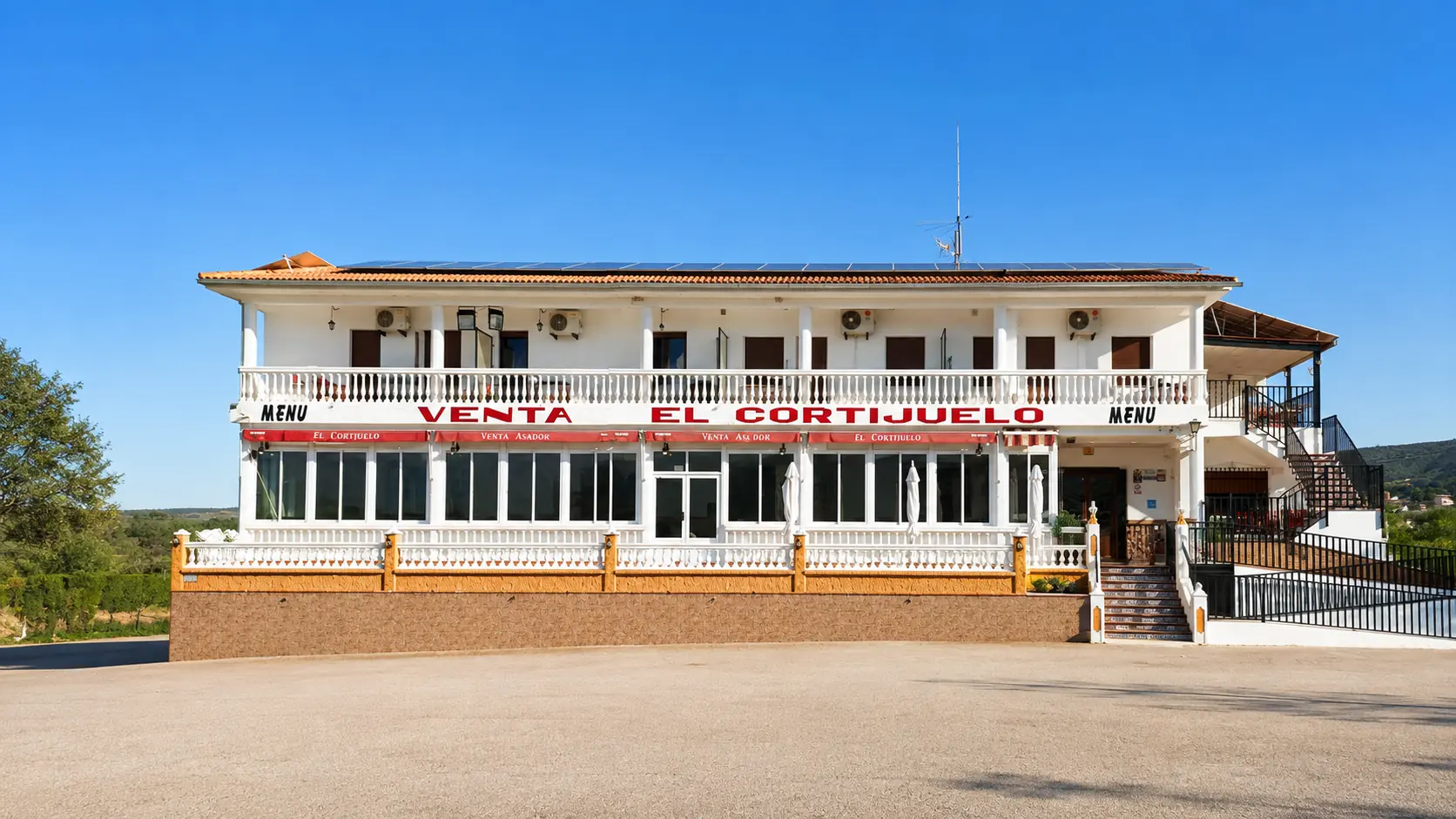 Vista frontal de Venta El Cortijuelo, restaurante asador en Villanueva del Trabuco, Málaga, con su amplia fachada, terraza y entrada principal.