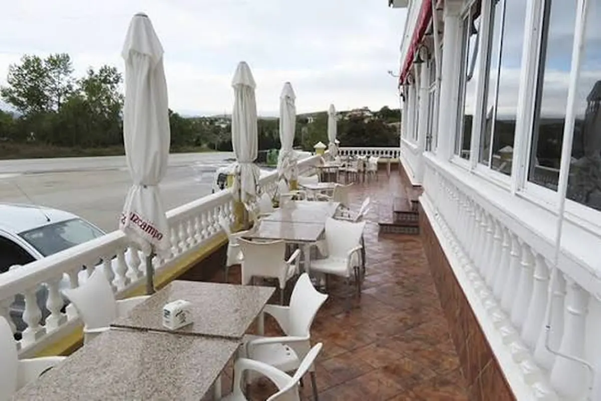 Terraza exterior de Venta El Cortijuelo con mesas y sombrillas